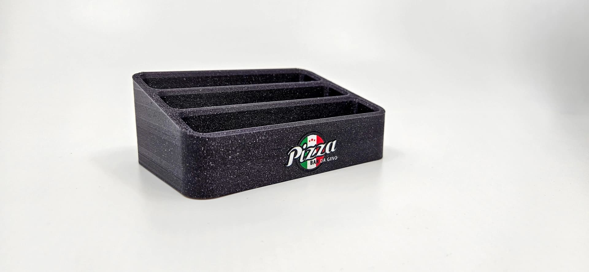 Zakázkový 3D tištěný stojánek na stůl s UV logem pro restauraci.